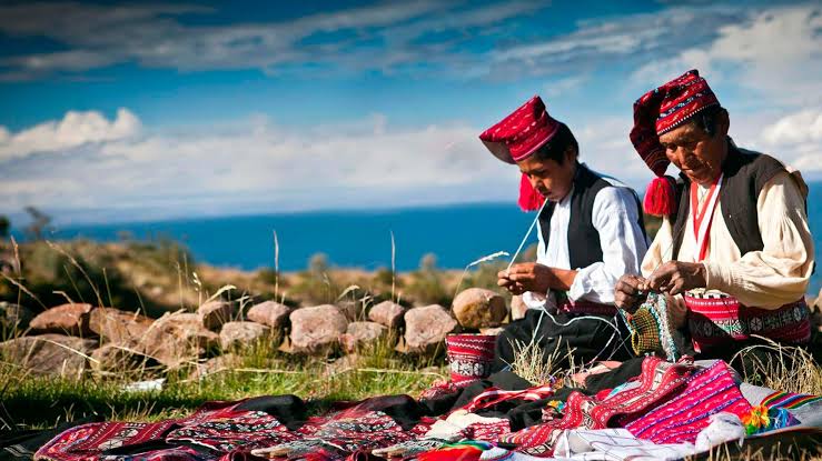 Artesanos de Taquile tejiendo junto al Lago Titicaca