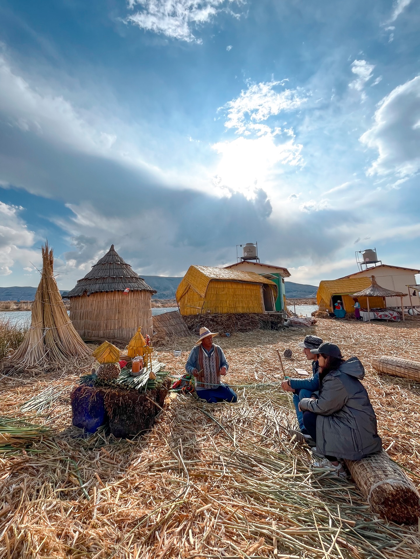 Visitantes con un anfitrión en una isla flotante de los Uros